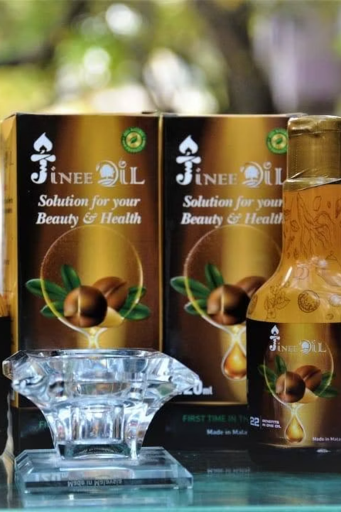 Jinee Oil bottle and boxes with a glass dish of oil
